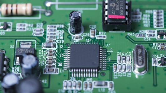 Macro view of an industrial control circuit board featuring essential passive components, including SMD industrial resistors, electrolytic capacitors, and a central microcontroller IC for automation systems.